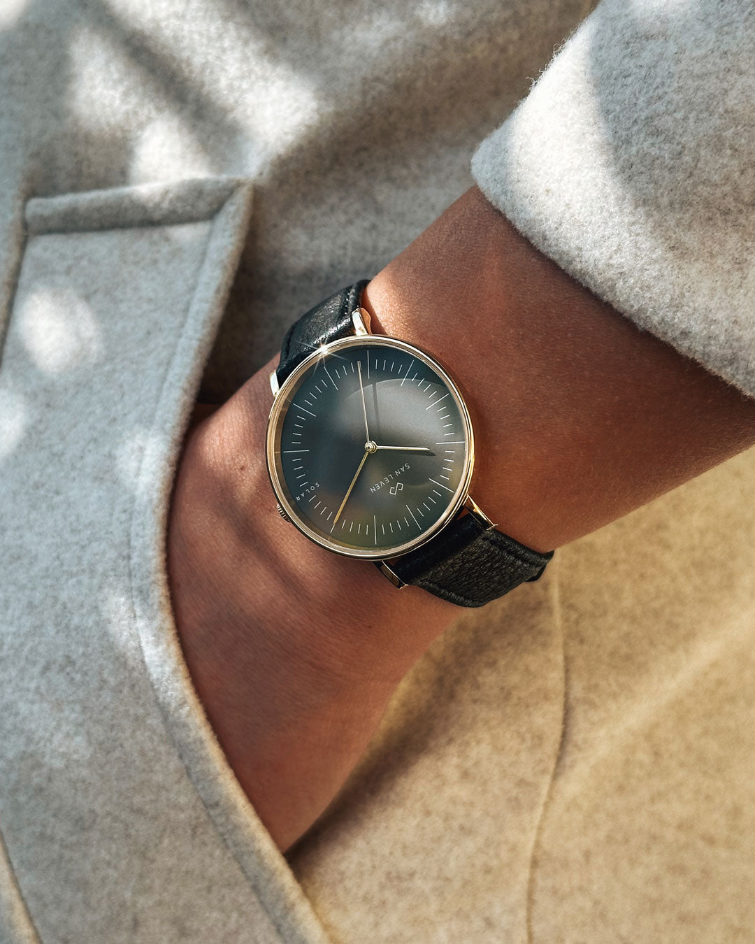 SAN LEVEN SPARK Bioleder Black 36 mm Gold Shadow Solaruhr am Handgelenk – minimalistische goldene Uhr mit schwarzem Biolederarmband im Tageslicht.